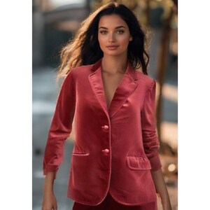 May include: A red velvet blazer with a notched lapel, two front pockets, and two buttons. The blazer has long sleeves and a tailored fit. The jacket is part of a suit.