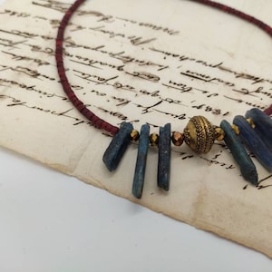 Collar de cianita azul con cuentas heishi rojas y cuentas de latón.