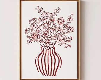 Arte de parede em tons de vinho: Tela emoldurada em vermelho escuro, estampa botânica em tons de vinho, vaso marrom com flores.