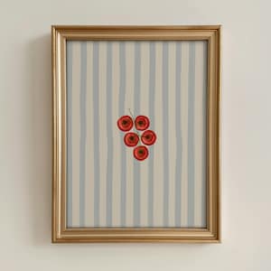 May include: A framed print with a watercolour illustration of five red cherry tomatoes on a green stem. The background has vertical stripes in light blue and beige. The frame is gold.