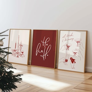 Puede incluir: Tres impresiones artísticas enmarcadas con temática navideña. Las impresiones presentan dibujos lineales en rojo sobre un fondo crema. Una impresión dice "Ho Ho Ho" en escritura blanca. Otra dice "eat, drink, & be merry".