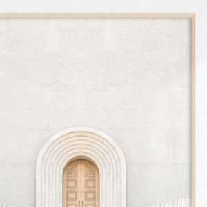 May include: A white wall with a wooden door set in an arched doorway. The arch is made of white stone with a series of concentric arches.