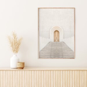 May include: A framed photograph of a white building with a large arched doorway and a set of stairs leading up to it. The doorway is made of wood and has a light brown color. The stairs are made of concrete and have a gray color.