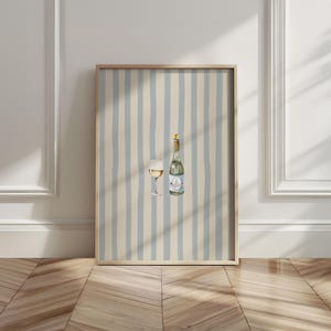 May include: A framed print featuring a watercolor illustration of a wine bottle and a glass of white wine. The background has a striped pattern in light blue and beige. The frame is made of wood.