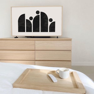 May include: A wooden tray with a white ceramic mug and a white remote control on a white bed. The tray is on top of a white bedspread.