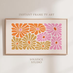 May include: A digital art print featuring a pattern of stylised flowers in shades of orange, pink, and yellow. The print is framed in a light wood frame.