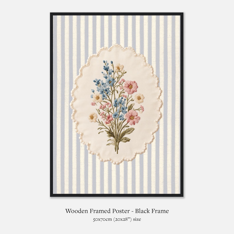 K&ouml;nnte beinhalten: Gerahmtes Poster mit einem gestickten Blumenstrau&szlig; in Rosa, Blau und Gelb. Der Strau&szlig; befindet sich auf einem cremefarbenen, gewellten Oval vor einem gestreiften Hintergrund. Der schwarze Rahmen enth&auml;lt ein 50x70cm Poster.