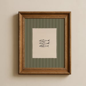 Pu&ograve; includere: Una stampa artistica incorniciata con tre pesci stilizzati neri su sfondo crema. La stampa &egrave; ambientata su un motivo a righe verdi e bianche, racchiusa in una cornice di legno marrone, per la decorazione murale.
