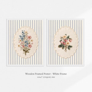 May include: Two framed posters with white frames. Each poster features a floral design within an oval, scalloped border. The background is a striped pattern of white and light blue. The text at the bottom reads: Wooden Framed Poster - White Frame 11x14" (27x35cm) size.