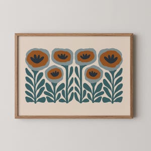 May include: A framed art print featuring a stylized floral design. The artwork showcases six flowers with orange and navy blue petals, set against a cream background. The stems and leaves are a deep teal color, all within a wooden frame.
