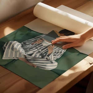 May include: An illustration of a person in striped pajamas, holding a book and a white coffee cup. The person is sitting on a green surface. The image is partially covered by a rolled-up piece of paper.