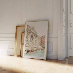 May include: A framed photograph of the Trevi Fountain in Rome, Italy. The fountain is a popular tourist destination and is known for its beautiful architecture and cascading water.