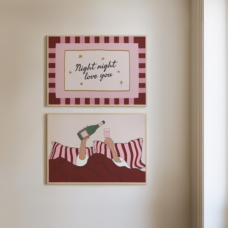 K&ouml;nnte beinhalten: Zwei gerahmte Kunstdrucke. Der obere Druck hat einen rosa-burgunderfarbenen Streifenrand mit dem Text "Night night love you" in Schreibschrift. Der untere Druck zeigt eine Person, die im Bett Champagner in ein Glas gie&szlig;t, mit rosa-burgunderfarbenen Kissen.
