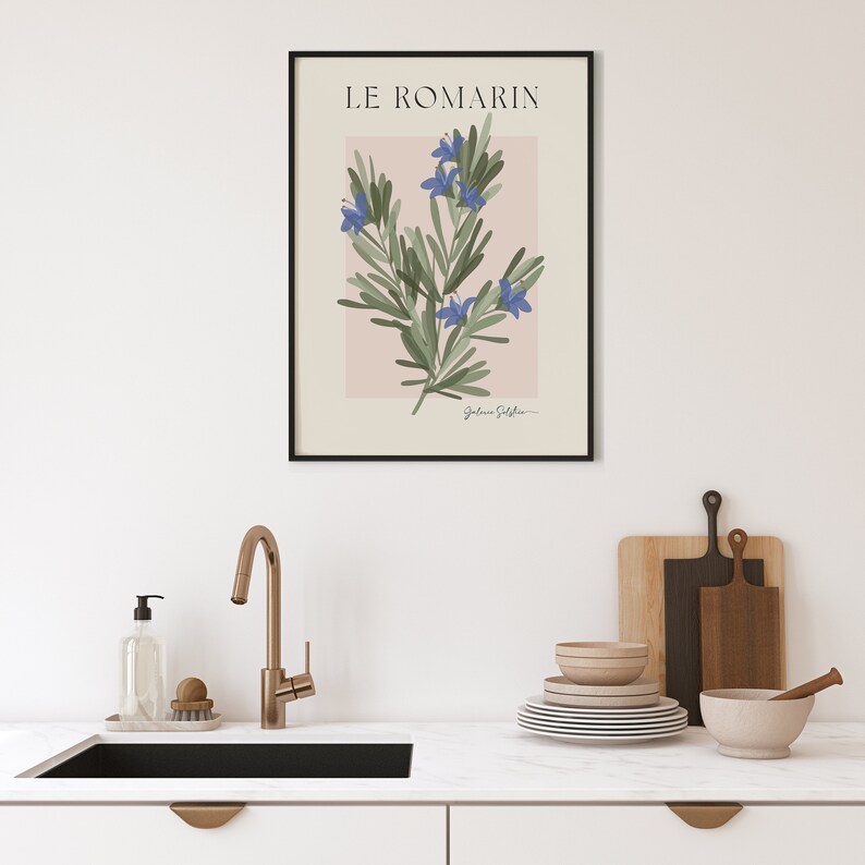 Op de afbeelding: Een zwart ingelijste print met een botanische illustratie van rozemarijn met blauwe bloemen op een lichtroze achtergrond. De titel "LE ROMARIN" staat bovenaan de print.