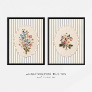 May include: Two framed floral prints. Each print features a detailed botanical illustration within a cream-colored, scalloped oval. The backgrounds are light blue and white striped. The frames are black. The size is 11x14 inches.