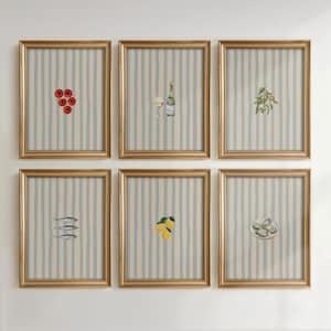 Może przedstawiać: Sześć oprawionych wydruków artystycznych ze złotymi ramami. Każdy wydruk przedstawia inną akwarelową ilustrację: pomidory, wino z butelką, oliwki, ryby, cytryny i ostrygi. Tło ma niebiesko-biały wzór w paski.