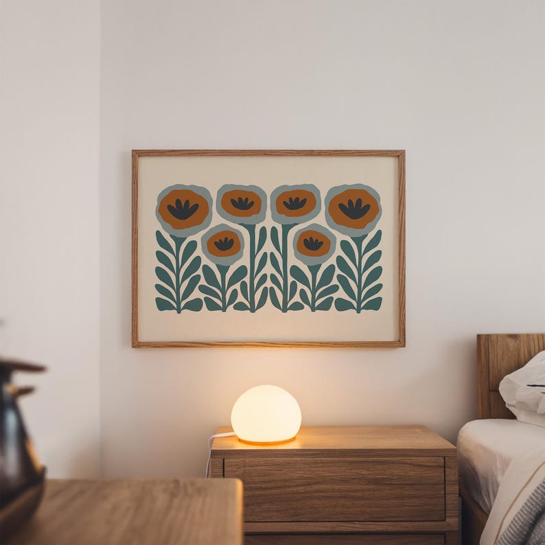 May include: A framed floral art print featuring stylized orange and blue flowers with green stems and leaves. The artwork hangs above a wooden nightstand with a glowing spherical lamp. The room has a neutral color palette.