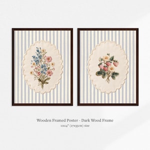 May include: Two framed floral prints. Each print features a bouquet of flowers on an oval, cream-colored background, set against a striped, light blue and white backdrop. The frames are dark wood. The size is 11x14 inches.