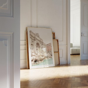 May include: A framed photograph of the Trevi Fountain in Rome, Italy. The fountain is a popular tourist destination and is known for its beautiful architecture and cascading water.