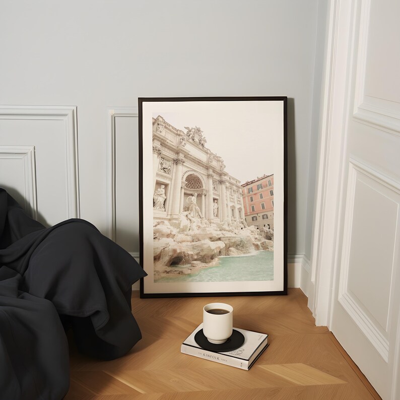 May include: A framed black and white photograph of the Trevi Fountain in Rome, Italy. The fountain is a popular tourist destination and is known for its beautiful architecture and cascading water.
