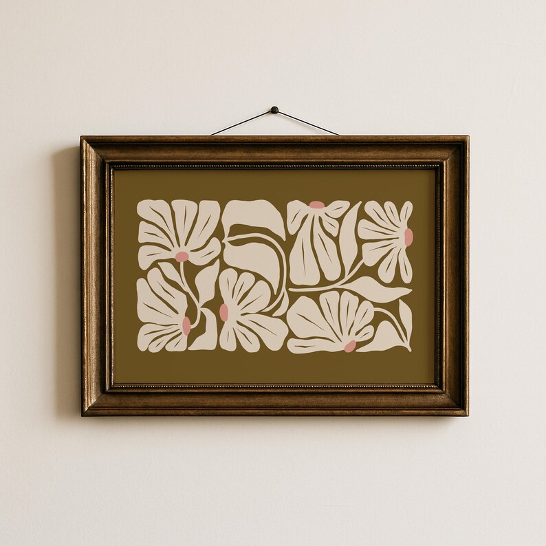 May include: A framed floral art print featuring a botanical design. The artwork showcases stylized cream-colored flowers with pink centers against an olive-green background. The frame is a dark brown color.