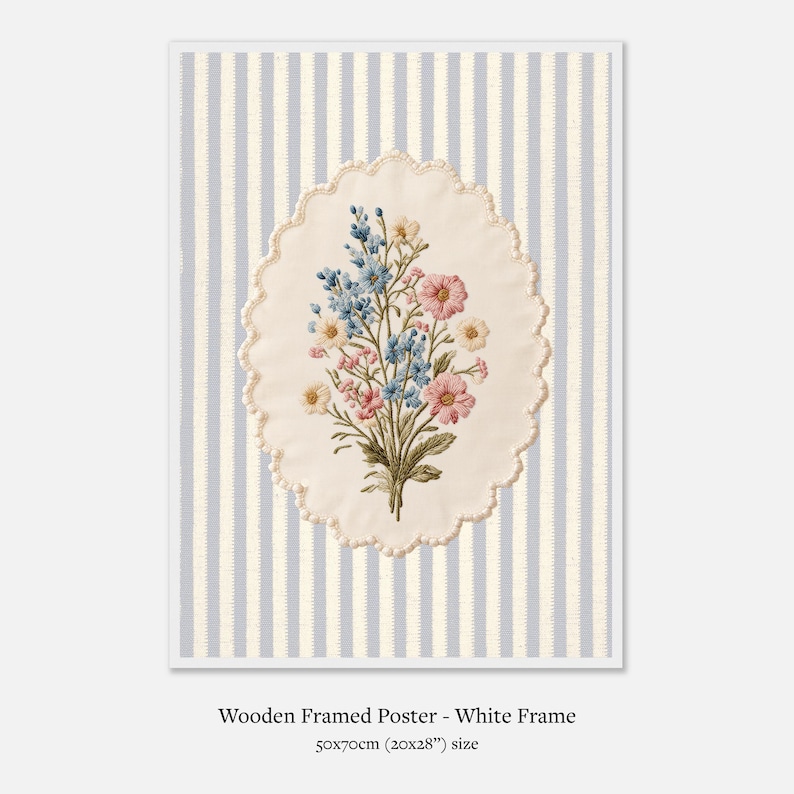 K&ouml;nnte beinhalten: Gerahmtes Poster mit wei&szlig;em Rahmen. Das Kunstwerk zeigt ein ovales, gesticktes Blumendesign in Rosa, Blau und Gelb auf gestreiftem Hintergrund. Das Poster misst 50x70cm.