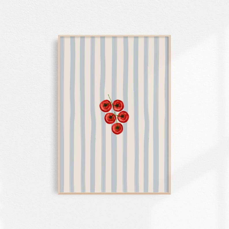 May include: A framed art print showing a watercolour illustration of a cluster of red tomatoes on a green stem. The background has vertical stripes in light blue and cream colours. The frame is a light wood colour.