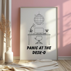Peut inclure: Impression en noir et blanc représentant un bureau avec un ordinateur, une lampe et une boule à facettes. Le texte "PANIC AT THE DESK-O" est affiché en dessous du bureau. L'impression est encadrée.