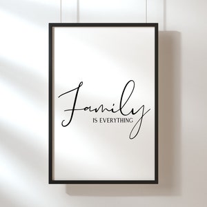 Op de afbeelding: Een zwart ingelijst print met de tekst "Family is everything" in een cursief schrift.