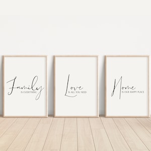 Op de afbeelding: Drie ingelijste prints met zwarte kalligrafie op een witte achtergrond. De prints luiden "Family is everything", "Love is all you need" en "Home is our happy place".