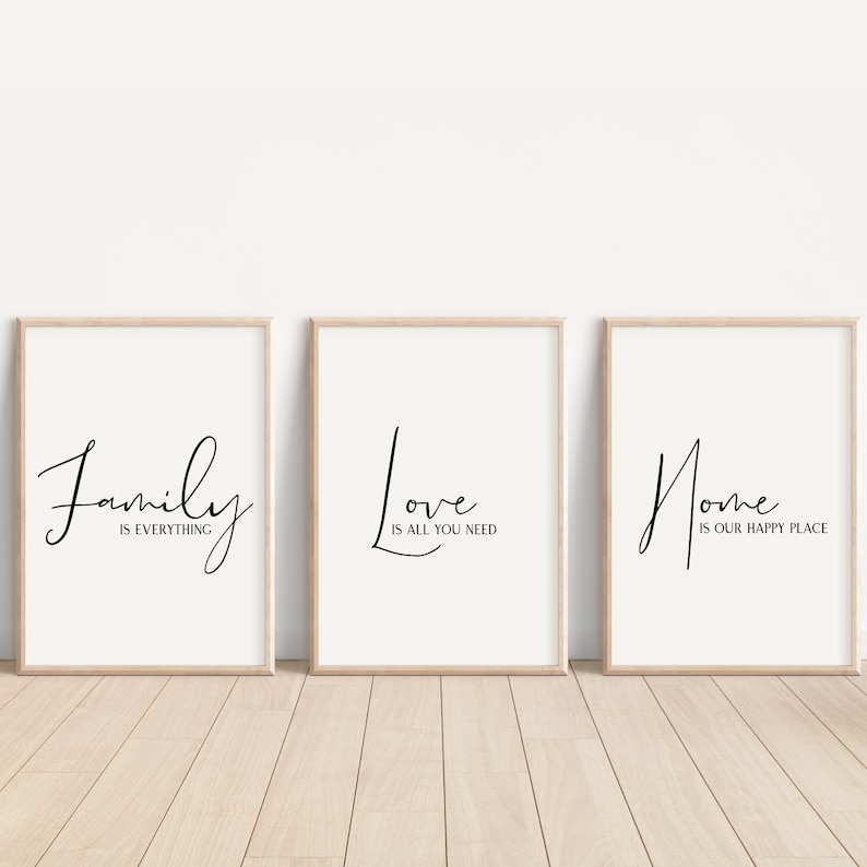 Op de afbeelding: Drie ingelijste prints met zwarte kalligrafie op een witte achtergrond. De prints luiden "Family is everything", "Love is all you need" en "Home is our happy place".