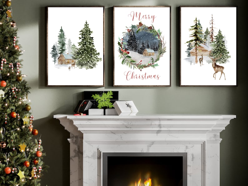 May include: Three framed watercolor prints depicting winter scenes. One shows a cabin in a snowy forest, another features a wreath with the text "Merry Christmas," and the third displays a cabin and deer. The frames are dark brown.