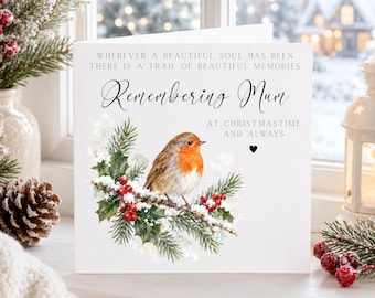 May include: A white greeting card featuring a watercolor illustration of a robin perched on a snowy pine branch with red berries. The text reads: WHEREVER A BEAUTIFUL SOUL HAS BEEN THERE IS A TRAIL OF BEAUTIFUL MEMORIES, Remembering Mum, AT CHRISTMASTIME AND ALWAYS.