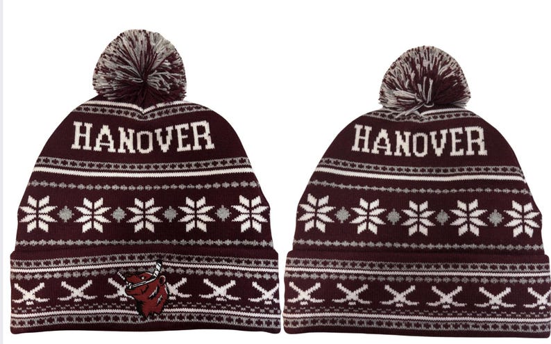 Pu&ograve; includere: Due berretti in maglia bordeaux con la scritta bianca "HANOVER". I berretti hanno un motivo a fiocco di neve e un pompon sulla parte superiore. Un berretto ha un logo bordeaux e bianco di un orso con mazze da hockey.