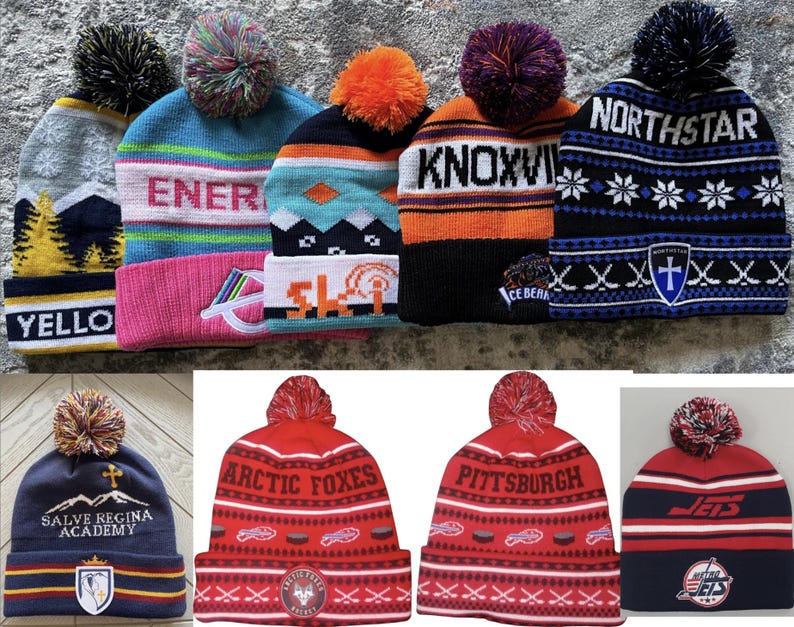 Pu&ograve; includere: Una collezione di berretti invernali con pompon. I berretti sono in vari colori, tra cui blu, rosso, arancione e grigio. Alcuni berretti hanno scritte come "YELLO", "ENER", "KNOXVI", "NORTHSTAR", "ARCTIC FOXES" e "PITTSBURGH".