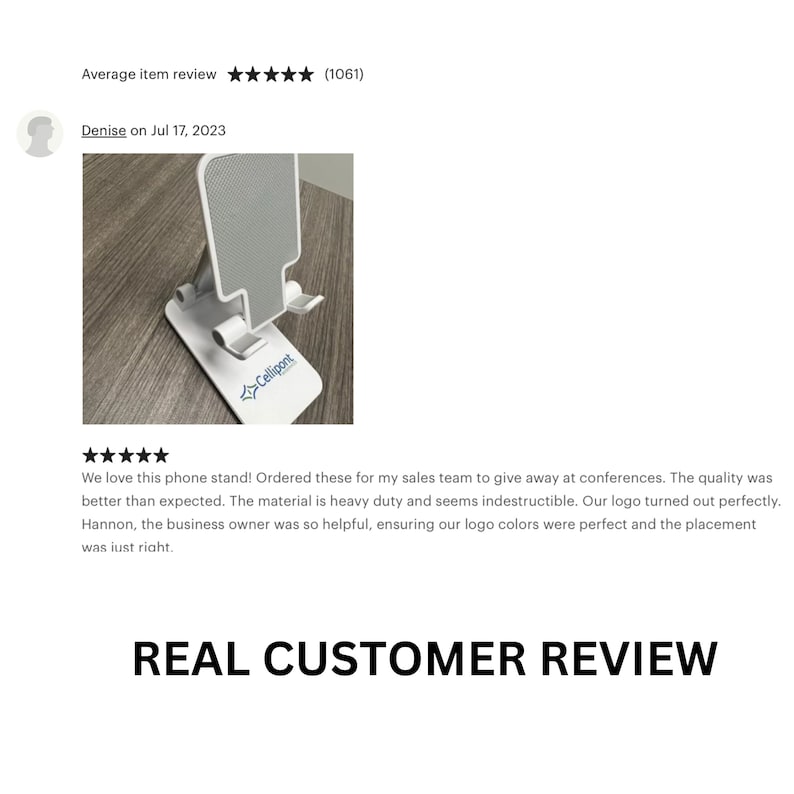 May include: A white phone stand with a gray textured surface. The stand has a fold-out design and a logo that says "Cellipont".