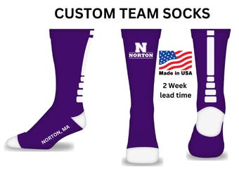 May include: Purple custom team socks with white accents and the text "NORTON, MA" on the left sock. The right sock has a white "N" with "NORTON" below it. The text "Made in USA" and "2 Week lead time" is also visible.