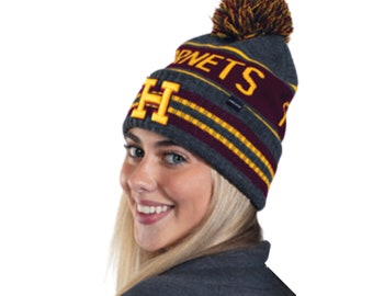 May include: Gray knit beanie with a pom pom on top. The beanie has a burgundy and gold stripe pattern with the word "NETS" and a large "H" embroidered in gold.