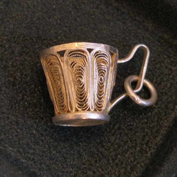 Silver Teacup Filigree Charm from Edwardian England, Sterling Circa 1900s / Measures: 13mm across the top, handle adds 6mm, 12.5 mm tall.