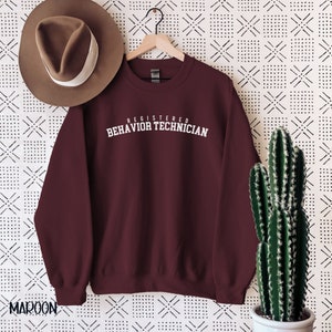 May include: Maroon sweatshirt with white text that reads "Registered Behavior Technician".