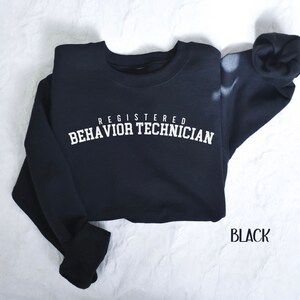 May include: Black sweatshirt with white text that reads "Registered Behavior Technician".