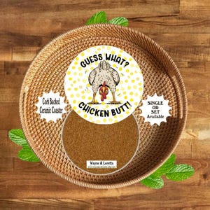 May include: A round ceramic coaster with a cork backing featuring a yellow polka dot pattern and a central illustration of a chicken viewed from behind. The text reads GUESS WHAT? CHICKEN BUTT! with the brand name Wayne & Loretta at the bottom.