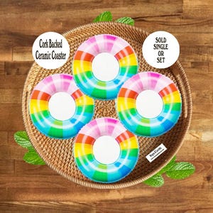 May include: Four round ceramic coasters with cork backing, each featuring a vibrant rainbow-colored ring pattern with a white center. Text on the image reads Cork Backed Ceramic Coaster and SOLD SINGLE OR SET, with a small logo reading Wayne & Lovetta.