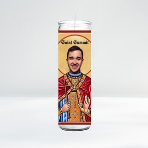 May include: A white candle with a red and gold label featuring a portrait of a man with the text "Saint Summit".
