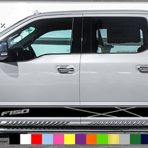 May include: A white pickup truck with a black and white vinyl graphic on the side. The graphic features the text "F150" and a geometric pattern. A colour palette is visible at the bottom of the image, offering various choices.