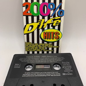 Może przedstawiać: Czarna kaseta z białą etykietą. Etykieta zawiera tekst "Various Artists - 200% Dance Hits" i "Side 1 Made in Canada". Kaseta jest produktem PolyTel i zawiera tekst "PolyTel 516 745 4 This compilation 1994 PolyTel a division of PolyGram Group Canada Inc. Stereo".