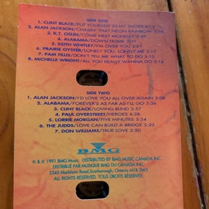 May include: A cassette tape case with a red, orange, and yellow background. The case lists the songs on the tape, including artists such as Clint Black, Alabama, and Alan Jackson. The case is labelled "Side One" and "Side Two". The BMG Music logo is at the bottom of the case.