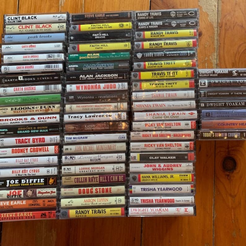 May include: A collection of vintage cassette tapes featuring country music artists such as Clint Black, Garth Brooks, Faith Hill, Alan Jackson, Wynonna Judd, Brooks & Dunn, Tracy Lawrence, Shania Twain, Ricky Van Shelton, Dwight Yoakam, and more.