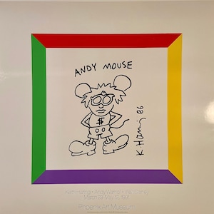 K&ouml;nnte beinhalten: Ein wei&szlig;er Kunstdruck mit einer schwarz-wei&szlig;en Cartoon-Maus mit dem Titel "ANDY MOUSE". Der Druck hat einen farbigen Rand. Signiert "K. Haring '86". Aus dem Phoenix Art Museum.