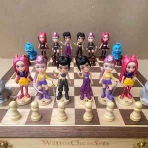 May include: A unique chess set featuring figurines of anime-style characters in various outfits, including a cat and blue animal pieces. The chess board is made of wood with a light brown and dark brown pattern. The text "WattosChessSets" is visible.